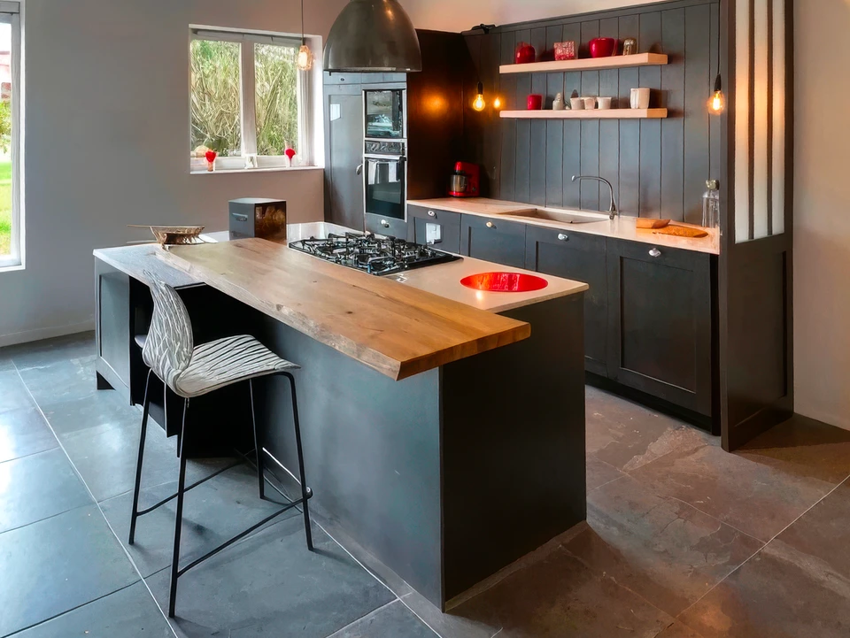 Jeune femme en tablier noir travaillant sur ordinateur portable dans cuisine professionnelle moderne, t&eacute;l&eacute;phone &agrave; l'oreille, prenant des notes