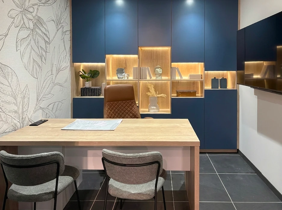 Cuisine moderne ouverte, coloris bordeaux mat, îlot central arrondi avec plan de travail blanc et étagères en bois naturel